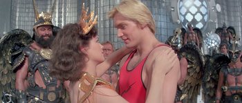 Movie still from “Flash Gordon” (1980), directed by Mike Hodges – A man and a woman are hugging each other in front of a crowd; Close Up shot, Over the shoulder angle