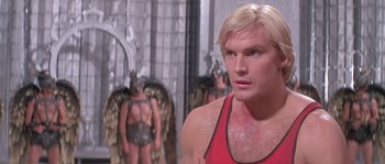 Movie still from “Flash Gordon” (1980), directed by Mike Hodges – A person wearing a red shirt; Close Up shot, Low angle