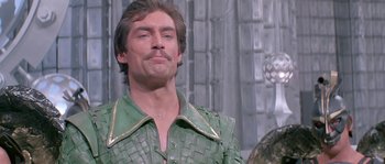 Movie still from “Flash Gordon” (1980), directed by Mike Hodges – A person wearing a green shirt; Close Up shot, Over the shoulder angle
