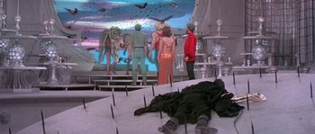 Movie still from “Flash Gordon” (1980), directed by Mike Hodges – A group of people standing on top of a platform; Wide shot, High angle