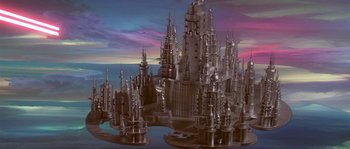 Movie still from “Flash Gordon” (1980), directed by Mike Hodges – An artistic rendering of a futuristic city with towers; Extreme Wide shot, High angle