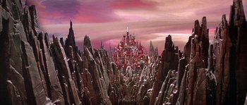 Movie still from “Flash Gordon” (1980), directed by Mike Hodges – A view of a castle in the middle of a valley; Extreme Wide shot, Low angle