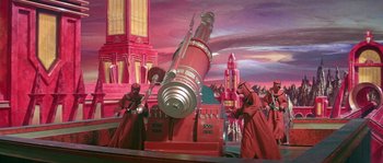 Movie still from “Flash Gordon” (1980), directed by Mike Hodges – A painting of a giant telescope with people in red robes around it; Extreme Wide shot, High angle