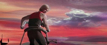 Movie still from “Flash Gordon” (1980), directed by Mike Hodges – A man in a red and black shirt holding a hammer; Wide shot, Low angle
