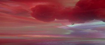 Movie still from “Flash Gordon” (1980), directed by Mike Hodges – A person riding a surfboard on top of a body of water; Extreme Wide shot, High angle