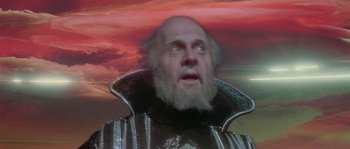 Movie still from “Flash Gordon” (1980), directed by Mike Hodges – An old man with a beard is looking up at the sky; Close Up shot, Low angle