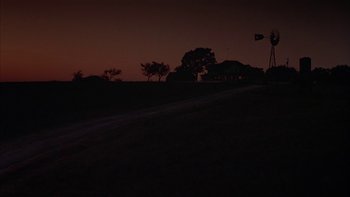 Movie still from “Flesh and Bone” (1993), directed by Steve Kloves – A view of a dark night sky with trees and a house; Extreme Wide shot, Low angle