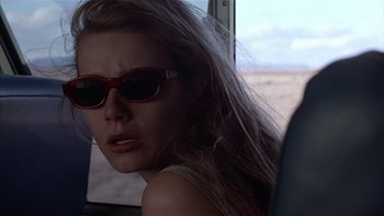 Movie still from “Flesh and Bone” (1993), directed by Steve Kloves – A woman wearing sunglasses sitting in a vehicle; Close Up shot, Low angle