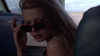 Movie still from “Flesh and Bone” (1993), directed by Steve Kloves – A woman with long blonde hair wearing sunglasses and holding a cell phone to her ear; Close Up shot, Low angle
