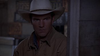 Movie still from “Flesh and Bone” (1993), directed by Steve Kloves – A man wearing a cowboy hat standing in front of a wooden wall; Close Up shot, Over the shoulder angle