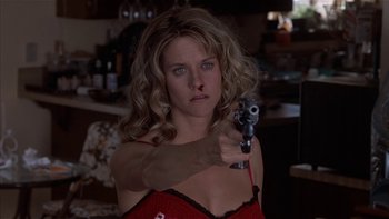 Movie still from “Flesh and Bone” (1993), directed by Steve Kloves – A woman holding a gun in her right hand; Close Up shot, Low angle