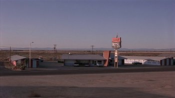 Movie still from “Flesh and Bone” (1993), directed by Steve Kloves – An old motel sign sits in the middle of the desert; Extreme Wide shot, High angle