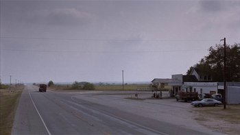 Movie still from “Flesh and Bone” (1993), directed by Steve Kloves – An empty road with a gas station on the side of the road; Extreme Wide shot, High angle