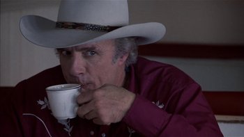 Movie still from “Flesh and Bone” (1993), directed by Steve Kloves – A man in a cowboy hat is drinking a cup of coffee; Close Up shot, Over the shoulder angle