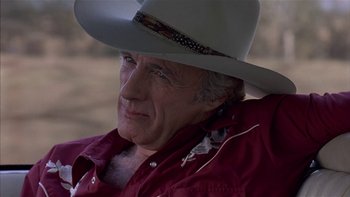 Movie still from “Flesh and Bone” (1993), directed by Steve Kloves – An older man wearing a cowboy hat and a red shirt; Close Up shot, Over the shoulder angle