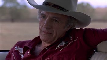Movie still from “Flesh and Bone” (1993), directed by Steve Kloves – An older man wearing a cowboy hat and a red shirt; Close Up shot, Over the shoulder angle