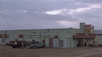 Movie still from “Flesh and Bone” (1993), directed by Steve Kloves – An old truck parked in front of a building; Extreme Wide shot, Low angle