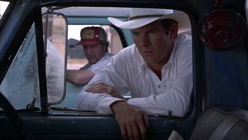 Movie still from “Flesh and Bone” (1993), directed by Steve Kloves – A man in a cowboy hat sitting in the back of a car; Medium shot, Over the shoulder angle