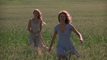 Movie still from “Flesh and Bone” (1993), directed by Steve Kloves – Two young women running through a field of grass; Medium shot, Low angle