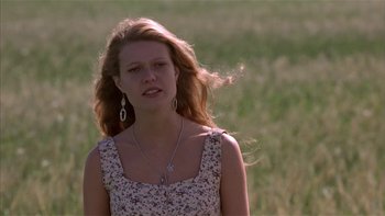 Movie still from “Flesh and Bone” (1993), directed by Steve Kloves – A woman with long hair wearing a floral dress; Close Up shot, Low angle