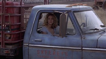 Movie still from “Flesh and Bone” (1993), directed by Steve Kloves – A woman sitting in the drivers seat of an old truck; Medium shot, Low angle