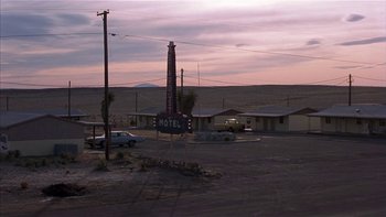 Movie still from “Flesh and Bone” (1993), directed by Steve Kloves – A motel sign in the middle of a deserted desert area; Extreme Wide shot, High angle