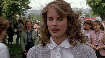 Movie still from “Footloose” (1984), directed by Herbert Ross – A young woman in a white shirt and a sweater; Close Up shot, Over the shoulder angle