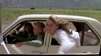 Movie still from “Footloose” (1984), directed by Herbert Ross – Three young women in the back seat of a white car; Medium shot, Low angle