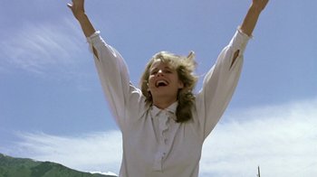 Movie still from “Footloose” (1984), directed by Herbert Ross – A woman in a white shirt is raising her hands; Medium shot, Low angle