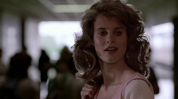Movie still from “Footloose” (1984), directed by Herbert Ross – A young woman with long blonde hair holding a hair brush in her hand; Close Up shot, Over the shoulder angle