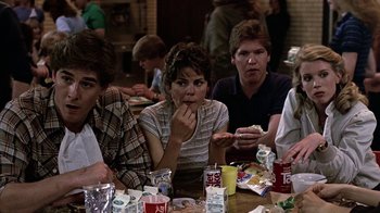 Movie still from “Footloose” (1984), directed by Herbert Ross – A group of people sitting at a table eating food; Medium shot, Over the shoulder angle