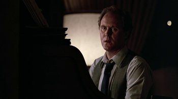 Movie still from “Footloose” (1984), directed by Herbert Ross – A man wearing a vest and a tie is playing the piano; Close Up shot, Over the shoulder angle
