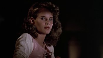 Movie still from “Footloose” (1984), directed by Herbert Ross – A young girl with long hair and a pink shirt; Close Up shot, Low angle