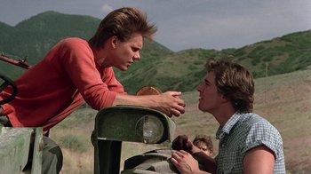 Movie still from “Footloose” (1984), directed by Herbert Ross – Two men talking to each other in a field; Medium shot, Over the shoulder angle