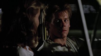 Movie still from “Footloose” (1984), directed by Herbert Ross – A man and a woman looking at each other in a car; Close Up shot, Over the shoulder angle