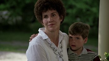 Movie still from “Footloose” (1984), directed by Herbert Ross – An older woman and a young boy pose for a picture; Close Up shot, Over the shoulder angle