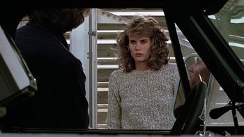 Movie still from “Footloose” (1984), directed by Herbert Ross – A woman looking at herself in a mirror; Medium shot, Over the shoulder angle
