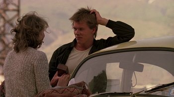 Movie still from “Footloose” (1984), directed by Herbert Ross – A young man is fixing his hair next to a woman; Medium shot, Over the shoulder angle