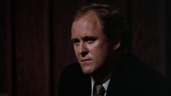 Movie still from “Footloose” (1984), directed by Herbert Ross – A person wearing a suit and tie; Close Up shot, Low angle