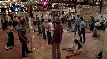 Movie still from “Footloose” (1984), directed by Herbert Ross – A group of people standing in a room with lights; Wide shot, High angle