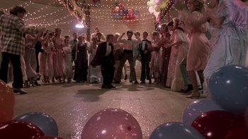 Movie still from “Footloose” (1984), directed by Herbert Ross – A group of people standing around a dance floor; Wide shot, High angle