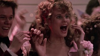Movie still from “Footloose” (1984), directed by Herbert Ross – A person with curly hair; Close Up shot, Over the shoulder angle
