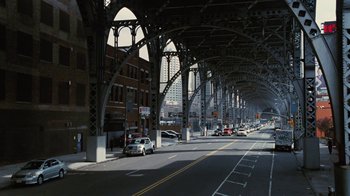 Movie still from “For Colored Girls” (2010), directed by Tyler Perry – A city street lined with parked cars under an overpass; Extreme Wide shot, Low angle