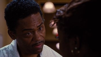 Movie still from “For Colored Girls” (2010), directed by Tyler Perry – A person with a cake; Close Up shot, Over the shoulder angle
