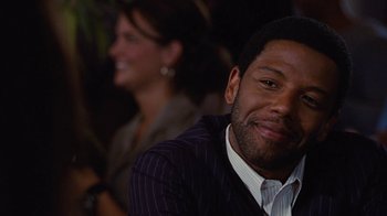 Movie still from “For Colored Girls” (2010), directed by Tyler Perry – A person wearing a suit and smiling; Close Up shot, Over the shoulder angle