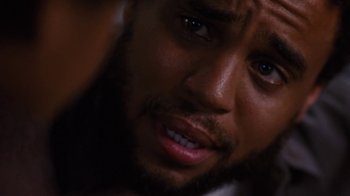 Movie still from “For Colored Girls” (2010), directed by Tyler Perry – A person with a beard looking at the camera; Close Up shot, Over the shoulder angle