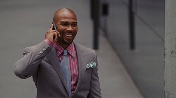 Movie still from “For Colored Girls” (2010), directed by Tyler Perry – A man in a suit talking on a cell phone; Medium shot, Overhead angle