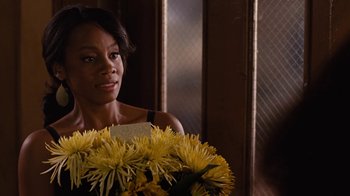 Movie still from “For Colored Girls” (2010), directed by Tyler Perry – A woman holding a bouquet of yellow flowers; Close Up shot, Over the shoulder angle