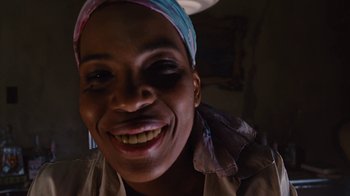 Movie still from “For Colored Girls” (2010), directed by Tyler Perry – A person with a head scarf smiling; Extreme Close Up shot, Low angle
