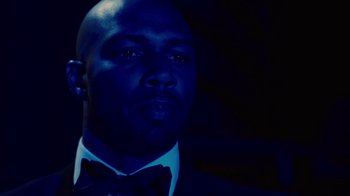 Movie still from “For Colored Girls” (2010), directed by Tyler Perry – A man wearing a suit and bow tie; Close Up shot, Over the shoulder angle